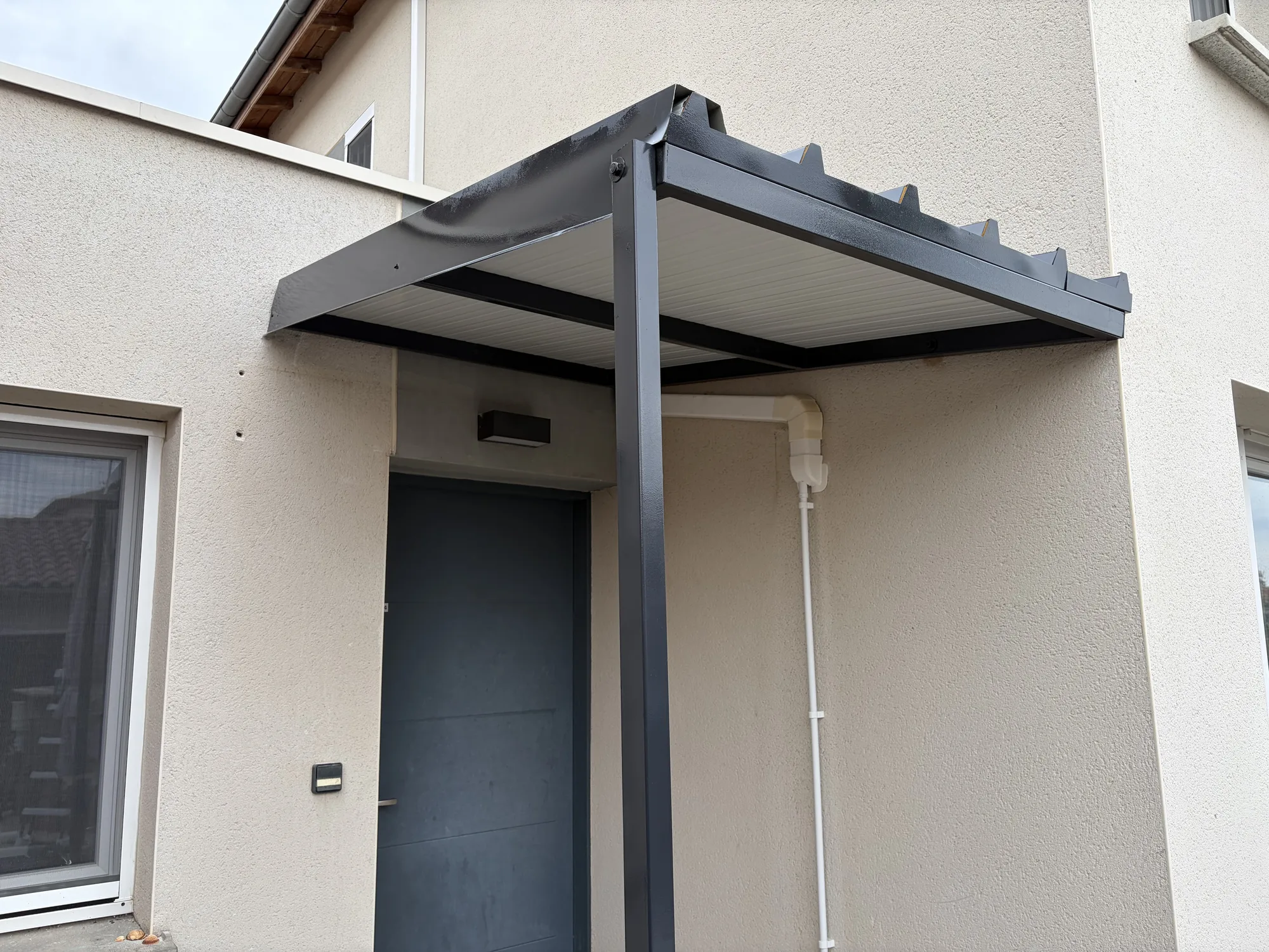 Auvent acier au-dessus d'une entrée de maison
