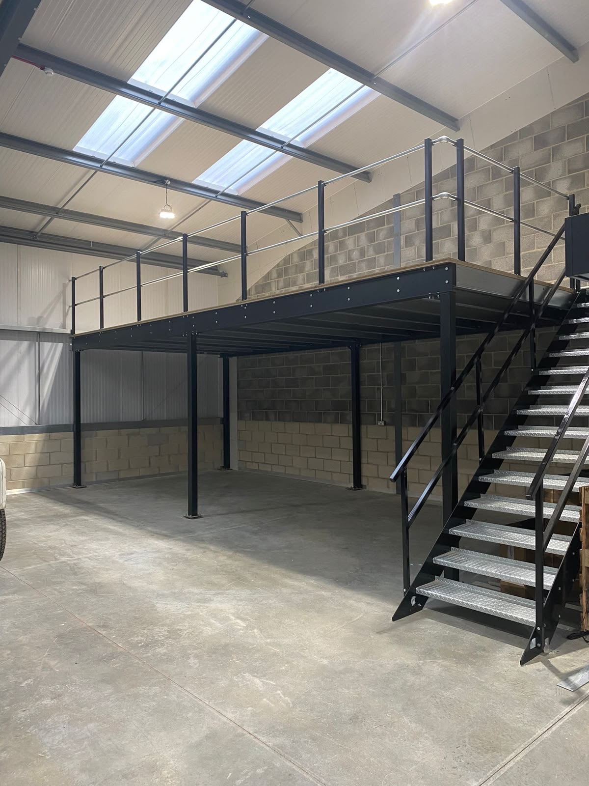 Mezzanine en acier avec escalier métallique dans un volume intérieur