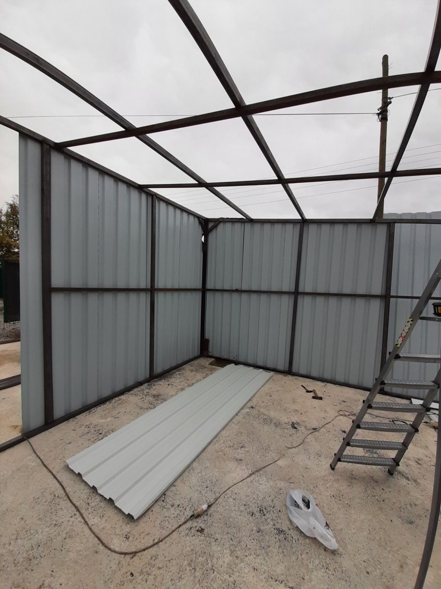 Ossature acier et bardage en cours de montage à l'intérieur d'un bâtiment